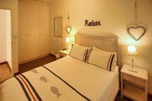 a bedroom with a bed and a heart sign on the wall at Birds View Holiday Home in Langebaan