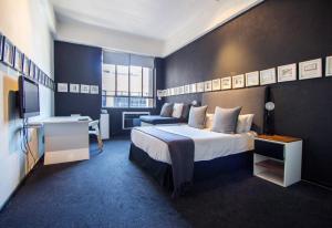 een hotelkamer met een groot bed en een bureau bij 12 Decades Art Hotel in Johannesburg