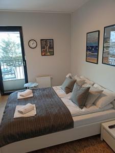 sypialnia z dużym łóżkiem z zegarem na ścianie w obiekcie OnHoliday Apartamenty ze strefą Relax & Fun, ul Lwowska 12 w Kołobrzegu