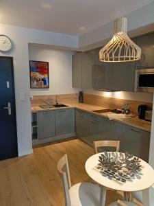kuchnia ze stołem, krzesłami i zegarem w obiekcie OnHoliday Apartamenty ze strefą Relax & Fun, ul Lwowska 12 w Kołobrzegu
