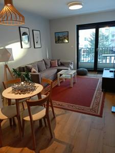 salon z kanapą i stołem w obiekcie OnHoliday Apartamenty ze strefą Relax & Fun, ul Lwowska 12 w Kołobrzegu