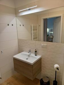 łazienka z umywalką i lustrem w obiekcie OnHoliday Apartamenty ze strefą Relax & Fun, ul Lwowska 12 w Kołobrzegu