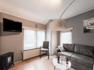 sala de estar con sofá y TV en Comfortable upstairs apartment with a terrace in Eefde en Eefde