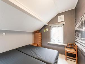 um pequeno quarto com uma cama e uma janela em Comfortable upstairs apartment with a terrace in Eefde em Eefde