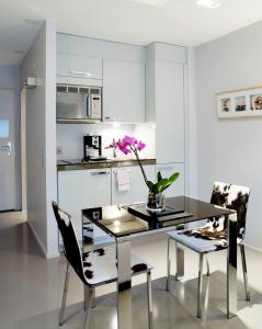 a kitchen with a table with a vase of flowers on it at VISIONAPARTMENTS Binzmühlestrasse 48 - contactless check-in in Zurich