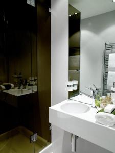 een witte badkamer met een wastafel en een spiegel bij VISIONAPARTMENTS Binzmühlestrasse 48 - contactless check-in in Zürich