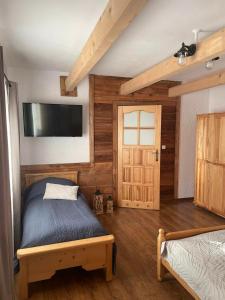 a bedroom with a bed and a flat screen tv at Apartament Naglaka in Ząb