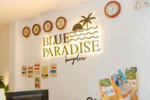 una señal que lee el paraíso azul en una pared con relojes en Blue Paradise Resort, en Phu Quoc