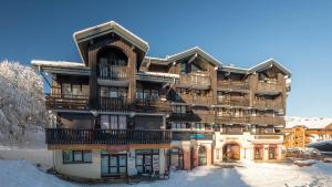 ein großes Holzgebäude im Schnee in der Unterkunft Grand Morillon-309 Appart vue pistes- 5 pers in Morillon