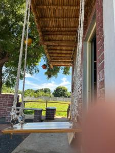 a porch swing with a view of a field at Woodside Haven in Auroville