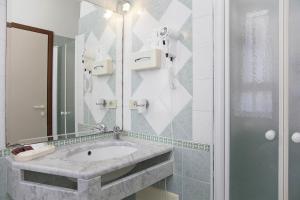 La salle de bains est pourvue d'un lavabo et d'un miroir. dans l'établissement Hotel Elpiro, à Lido di Jesolo