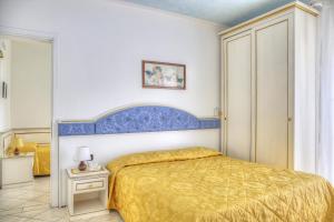 una camera con letto e testiera blu di Hotel Elpiro a Lido di Jesolo
