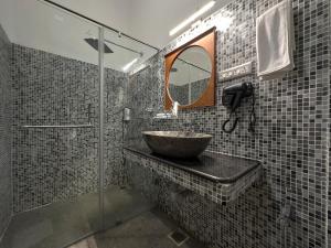 uma casa de banho com um lavatório e uma cabina de duche em vidro. em Villa Krish em Pondicherry