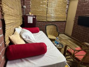 a room with two beds with red pillows at Woodside Haven in Auroville