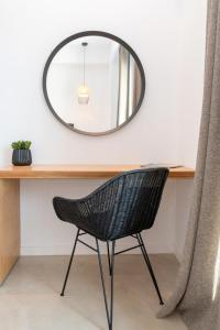 a black chair sitting in front of a desk with a mirror at alemár in Tinos Town