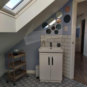 a bathroom with a sink and a staircase at Delightful & Picturesque Modern Detached Apartment, Next to Chester Zoo, Near Park and Ride to City Centre in Chester