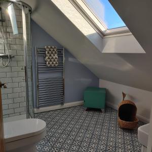 een badkamer met een schuin plafond en een dakraam bij Delightful & Picturesque Modern Detached Apartment, Next to Chester Zoo, Near Park and Ride to City Centre in Chester