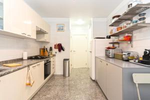a kitchen with white cabinets and a white refrigerator at Verde Mar Cascais Apartment in Estoril