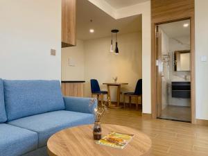 a living room with a blue couch and a table at PH Hotel & Apartment in Hai Phong
