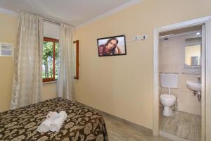 a bedroom with a bed and a sink and a toilet at Hotel & Restaurant Storyville in Cinquale