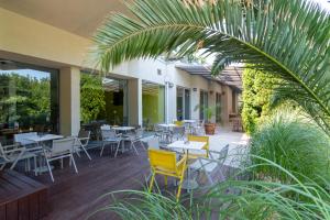 a restaurant patio with tables and chairs and plants at Hotel Excelsior - All Inclusive in Golden Sands