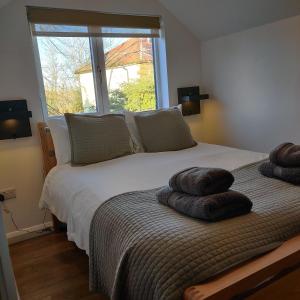 a bedroom with a bed with two pillows on it at Delightful & Picturesque Modern Detached Apartment, Next to Chester Zoo, Near Park and Ride to City Centre in Chester