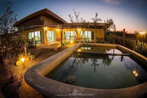 a house with a swimming pool in front of a house at Saline Hot Spring Resort นำ้พุร้อนเค็ม รีสอร์ท in Ban Nam Ron (1)