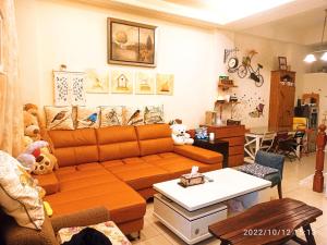 五結鄉的住宿－鳥語花香民宿，客厅配有橙色沙发和桌子