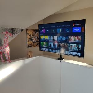 TV de pantalla plana en la parte superior de un armario en Delightful & Picturesque Modern Detached Apartment, Next to Chester Zoo, Near Park and Ride to City Centre, en Chester