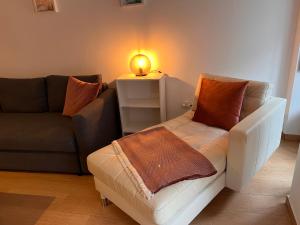 - un salon avec un canapé et une table avec une lampe dans l'établissement Casas do Olival Apartments, à Lisbonne