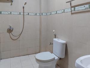 a bathroom with a toilet and a shower at Hotel Halmahera Palangkaraya Mitra RedDoorz in Palangkaraya