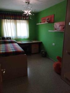 1 dormitorio con paredes verdes, 1 cama y escritorio en La casa de Ainhoa, en Teruel
