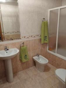 y baño con lavabo, aseo y espejo. en La casa de Ainhoa, en Teruel