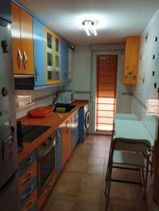 cocina con armarios azules, mesa y sillas en La casa de Ainhoa, en Teruel