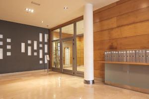 Cette grande chambre est dotée de murs en bois et d'une colonne. dans l'établissement The Rentals Collection - Urumea II, à Saint-Sébastien
