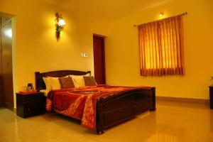 a bedroom with a large bed with a orange bedspread at New Ooty View Cottage in Ooty