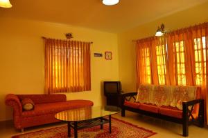 a living room with a couch and a table at New Ooty View Cottage in Ooty