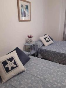a bedroom with two beds and a picture on the wall at Apartamento San Andrés in Teruel