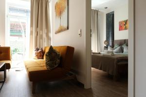 ein Wohnzimmer mit einem Sofa und einem Bett in der Unterkunft Apartments zur alten Konditorei in Schwerin