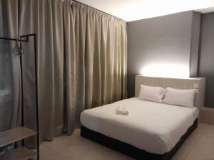 a bedroom with a bed with white sheets and pillows at The great in Ipoh