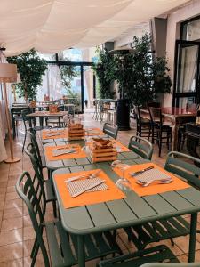 a green table in a restaurant with chairs and tables at Hotel Maremola in Pietra Ligure