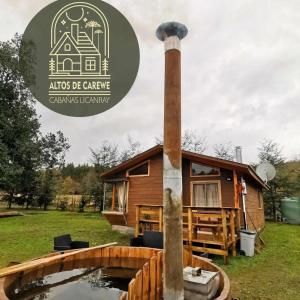 a tiny house with a pond in front of it at Cabañas Altos de carewe , Lican Ray chile in Licán Ray