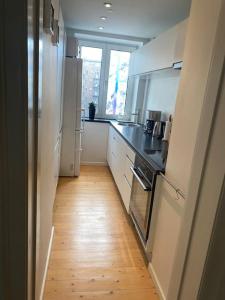 a kitchen with white appliances and a wooden floor at Martha in Aalborg