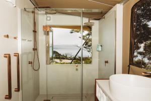 a bathroom with a shower and a sink at Drift Off Grid Luxury Eco Glamping in Tarakohe