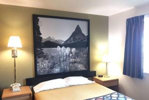 une chambre d'hôtel avec un lit avec une photo sur le mur dans l'établissement Super 8 by Wyndham Hamilton, à Hamilton