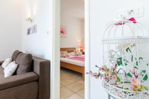 een woonkamer met een bed en een vogelkooi bij Slavka in Crikvenica