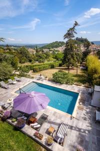 einen Blick über einen Pool mit Sonnenschirm und Stühlen in der Unterkunft Cottage provencal - Villa saint Marc in Forcalquier