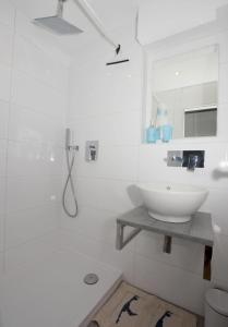 y baño blanco con lavabo y ducha. en 1-194, traumhafter Blick über Westerland im Haus Metropol, 8 Etage, en Westerland