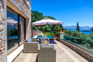 a patio with chairs and an umbrella and a pool at Villa Kallisto in Nydri