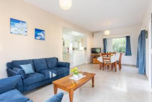 a living room with a blue couch and a table at Villa Lela Pente in Peyia